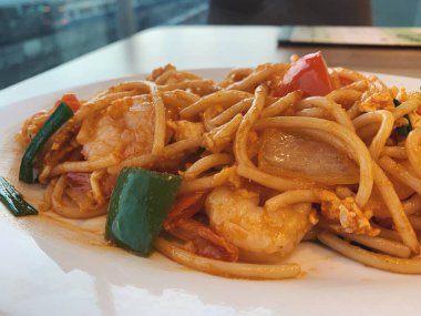 Karides, domates ve diğer sebzelerle nefis bir makarna. Restoranda beyaz tabağı kapat.