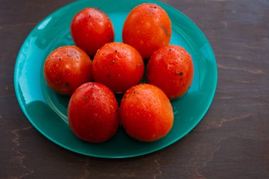 Olgun, sulu portakallı hurma mavimsi yeşil bir tabakta.