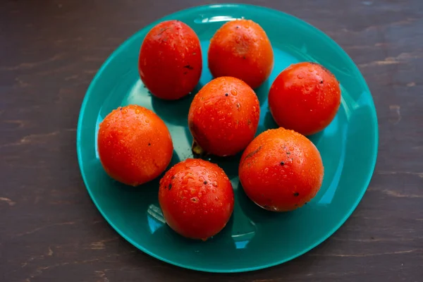 熟したジューシーなオレンジの柿を青緑色の皿に盛り — ストック写真