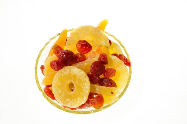 Yellow candied melon slices, pineapple rings and dogwood in a glass vase on a white background, top view in a glass vase on a white background, top view —  Fotos de Stock