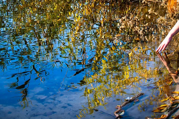 Reflections in the water, a womans hand touches the water, circles on the water — Foto de Stock