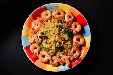 Renkli bir tabakta karides ve midyeli risotto..