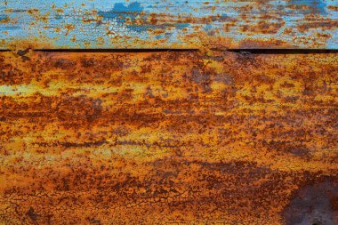 Eski paslı metal kapı, pasla turuncuya dönüşen maviye boyanmış. Çatlakların ve kabukların dokusu boya..