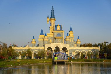 Taşkent, Özbekistan, 18 Ekim 2025: Mavi kuleleri suya yansıyan renkli fantezi şatosu, turizm, lunapark ve büyülü mimari temalar için mükemmel