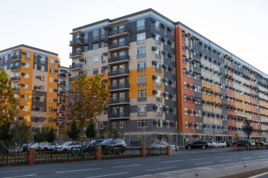 Modern multi-storey residential buildings with colorful facades and parked cars. Urban architecture scene on a clear day