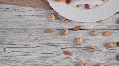 Antep fıstıklı kruvasan, kremalı şam fıstıklı kek ve ahşap bir masada bir fincan kahveyi gösteren videodan yakın çekim. Fıstıklı kahvaltı konsepti.