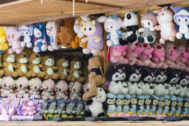 Taşkent, Özbekistan, 23 Ocak 2026: Markette asılı renkli pelüş oyuncaklar koleksiyonu. Satılık parlak doldurulmuş hayvanlar, popüler karakterlerin sergilenmesi, çocuk oyuncakları ve sokak piyasası atmosferi