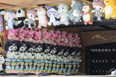 Taşkent, Özbekistan, 23 Ocak 2026: Markette asılı renkli pelüş oyuncaklar koleksiyonu. Satılık parlak doldurulmuş hayvanlar, popüler karakterlerin sergilenmesi, çocuk oyuncakları ve sokak piyasası atmosferi