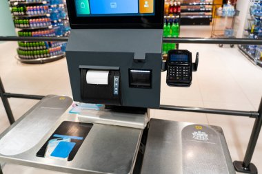 Ödeme kartı okuyucusu ve makbuzu olan bir süpermarkette otomatik çıkış terminali. Modern perakende teknoloji konsepti ve otomatik alışveriş süreci