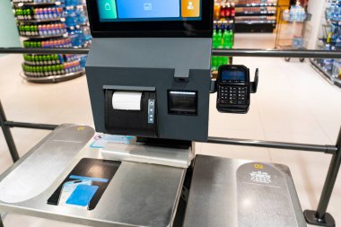 Ödeme kartı okuyucusu ve makbuzu olan bir süpermarkette otomatik çıkış terminali. Modern perakende teknoloji konsepti ve otomatik alışveriş süreci