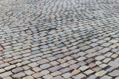 Dikdörtgen şeklindeki taş bloklarla döşenmiş eski bir taş kaldırım. Bir taşın bir yerinde delik var. Seçici odak ile perspektif fotoğraf