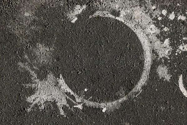 Asfalt yolda beyaz boya lekeleri ve boya lekesi var.