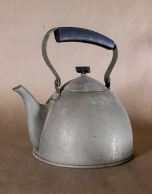 Hafif hasar görmüş eski bir alüminyum su ısıtıcısı.