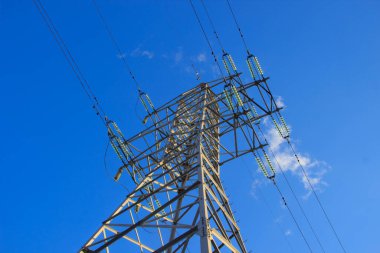 Mavi gökyüzü arka planında bir güç iletim hattı