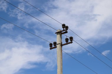 Mavi gökyüzü arka planında seramik pin tipi yalıtımlı bir güç iletim hattı