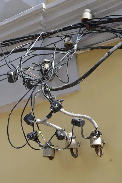 Six old-fashioned out-of-date ceramic insulators for a hand-made electric line mounted on an old dirty yellow wall