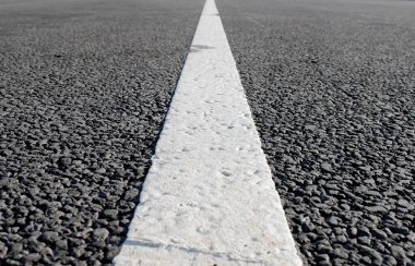 Tek düz beyaz yol işaretli boş bir yol. Seçici odaklı arkaplan fotoğrafı