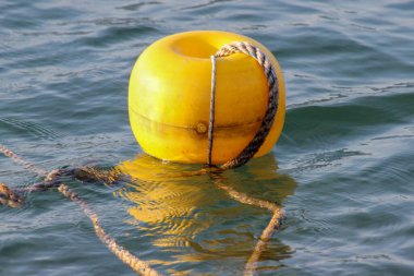 Sarı bir şamandıra halatla korunuyor.