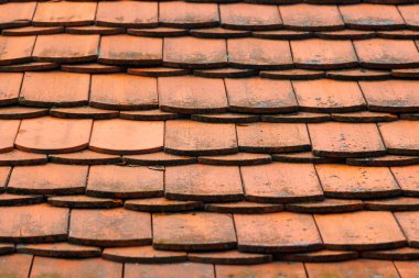 Arka plan olarak üstüste binen düz fayanslarla kaplı eski, kirli bir çatı. Seçici odak ile perspektif fotoğraf