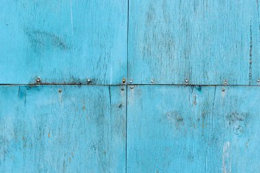 Maviyle boyanmış ve alt tabakaya çivilerle tutturulmuş birkaç eski çatlamış kaplama çarşaftan yapılmış bir duvar dokusu.