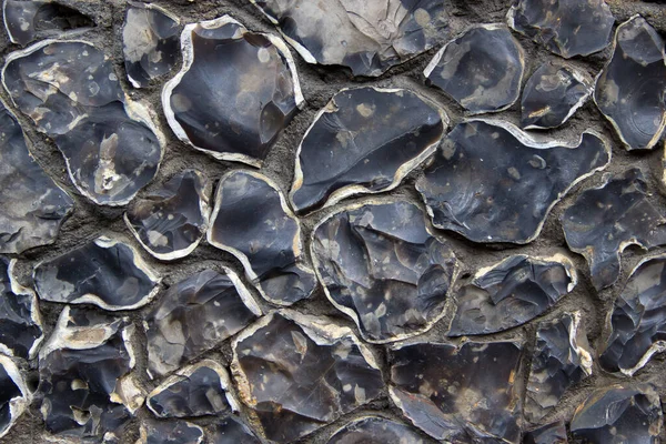 Beyaz kenarlı doğal taşlardan yapılmış çakıl taşı bir duvarın dokusu.