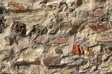 Ağır hasar görmüş alçıyla kaplanmış eski bir tuğla duvarın dokusu.