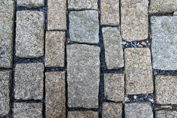 ブロックの間に砕けた岩の罰金と長方形の花崗岩のブロックで石畳の古い石畳 — ストック写真
