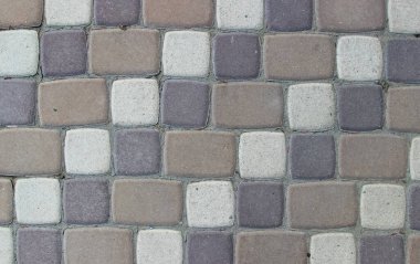Asfalt dokusu üç renkli döşeme taşından yapılmış ve kiremitler arasında çimento var.