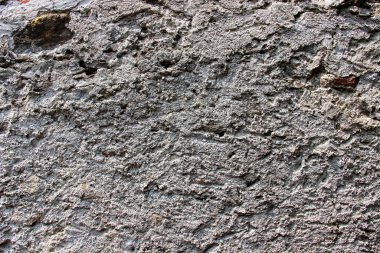 Kalın bir çimento katmanıyla kaplanmış eski hasarlı bir duvarın dokusu