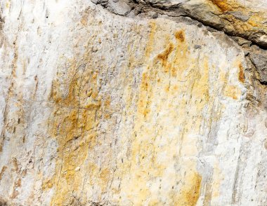 Renkli doğal bir taşın dokusu. Arka planda büyük bir çatlak var.