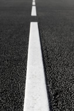 Tek çizgili beyaz yol işaretli boş bir asfalt yol. Seçici odaklı arkaplan fotoğrafı