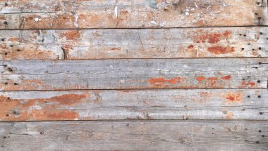 Çivilenmiş ahşap kalaslardan yapılmış duvar dokusu eski soyulmuş boyalarla kaplı ve arka plan olarak çatlamış.