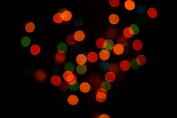 Οι πολύχρωμες πλευρές ή boke σε μαύρο φόντο. Καλά Χριστούγεννα και Καλή Χρονιά. Χριστουγεννιάτικο φόντο. — Φωτογραφία Αρχείου