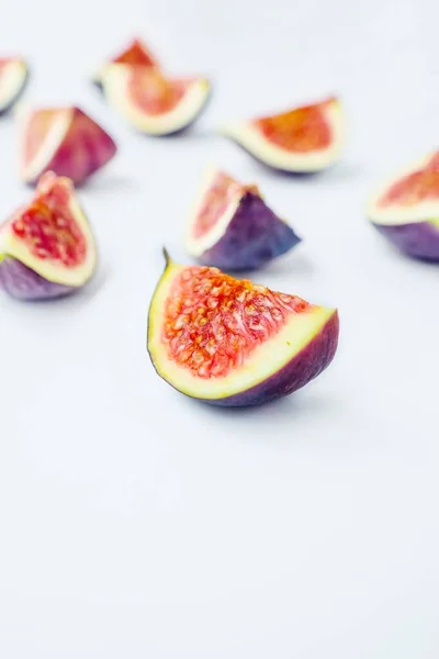 Figues mûres juteuses lumineuses sur un fond blanc coupé en morceaux. Le concept d'alimentation saine. — Photo