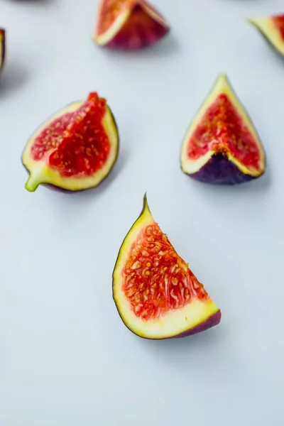 Figues mûres juteuses lumineuses sur un fond blanc coupé en morceaux. Le concept d'alimentation saine. — Photo