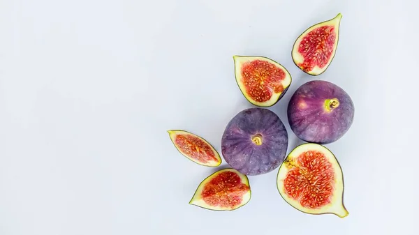 Strahlend saftige reife Feigen auf weißem Hintergrund, in Stücke geschnitten. Das Konzept der gesunden Ernährung. — Stockfoto