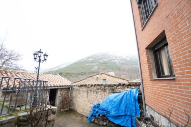 Arka planda sisli dağ olan eski bir evin çatısı..