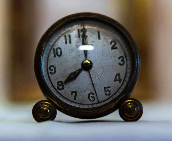 Close-up vintage clock with white base and blurred background