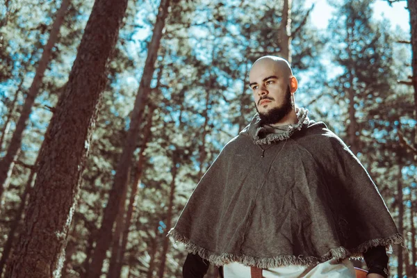 Viking with an angry look on his face in a Norwegian forest.