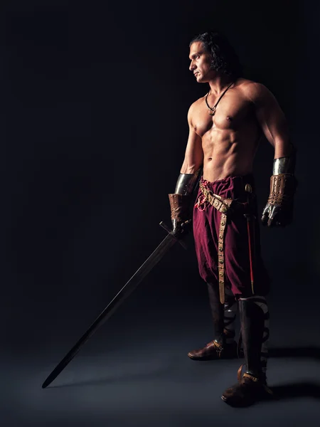 Halbnackter Krieger mit Schwert in mittelalterlicher Kleidung — Stockfoto