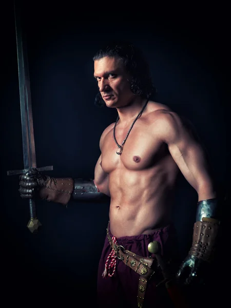 Bir kılıç ortaçağ giysileri ile yarı çıplak adam — Stok fotoğraf