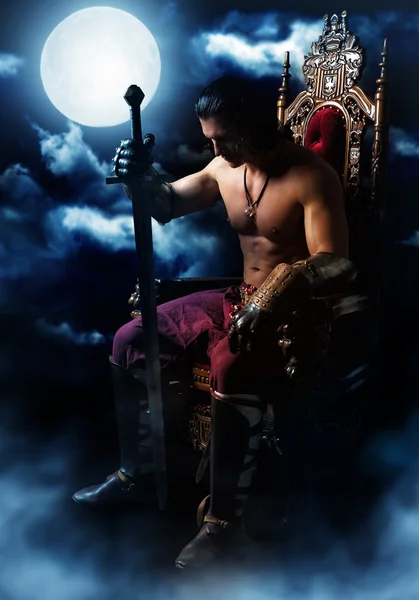 Medieval warrior on the throne on background of the moon — Stock Photo, Image