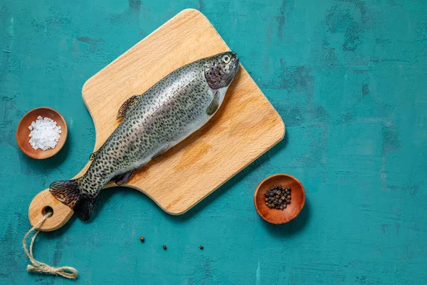 Fisk Öring Med Kryddor Skärbräda Turkos Bakgrund Kopieringsutrymme — Stockfoto