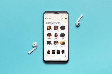 Almaty\ Kazakistan, Şubat 2021 Kulüp uygulaması mavi arka planda yeni iPhone ve kablosuz kulaklıklar ekranında açık..