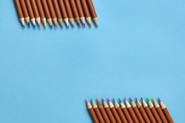 Mavi kâğıt arkaplanda renkli kalemler. Üst Manzara. Genç bir sanatçı için bir set. Yaratıcılık kavramı.