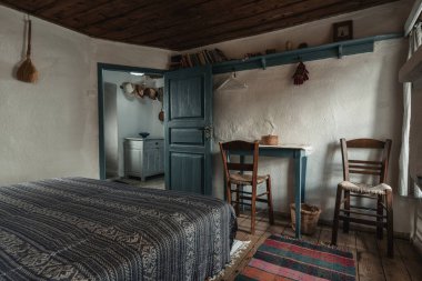 Geleneksel yatak odası. Tarihi köy evinde el yapımı ahşap mobilyalar ve geleneksel halk süsü.