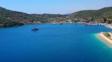 Yunanistan, Avrupa 'da beyaz kumsal plajı yakınlarındaki açık mavi sularda yelkenli tekneleriyle Akdeniz' deki lüks yat kulübüne havadan panoramik manzara
