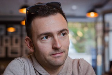 Kameraya bakan samimi bir adamın yakın plan portresi.