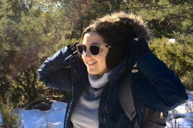 Sırt çantası ve güneş gözlüğü takan esmer kadın.