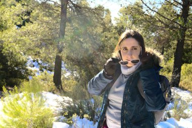 Sırt çantası takan esmer kadın güneş gözlüğü takmıyor.